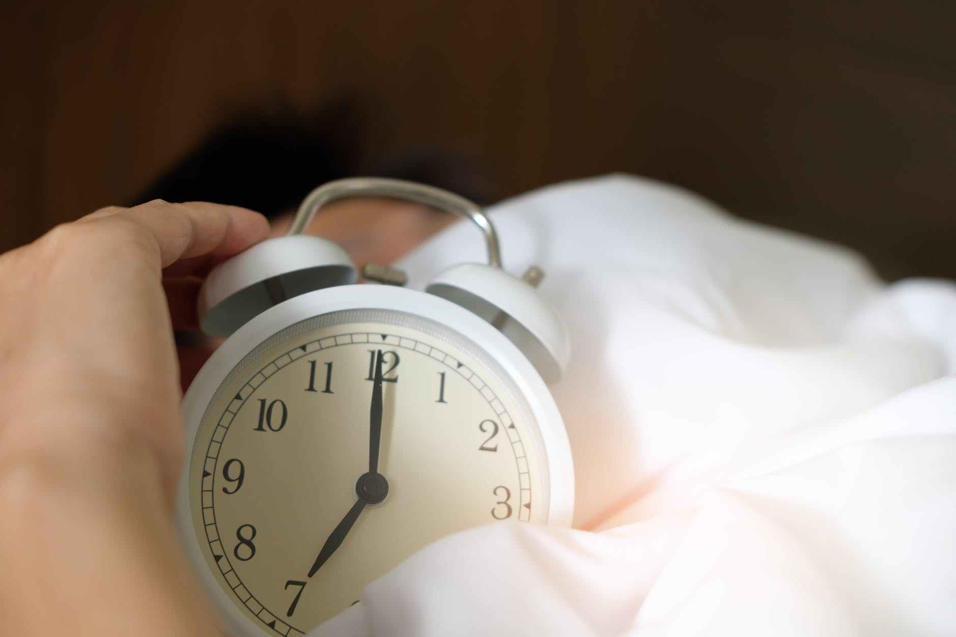 clock sleep photo of person holding alarm clock